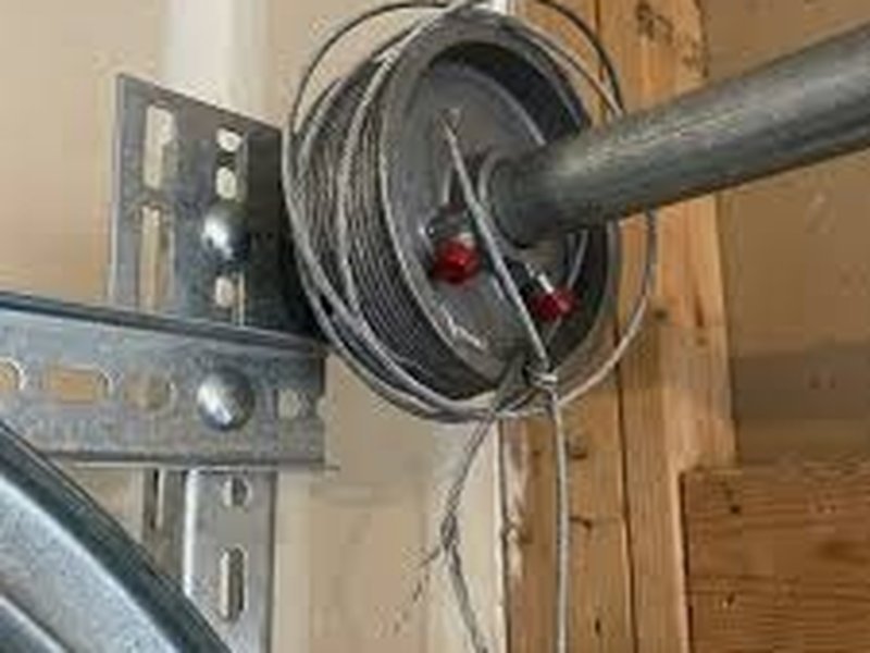 Lift cable drum and mounting bracket at the end of a torsion shaft