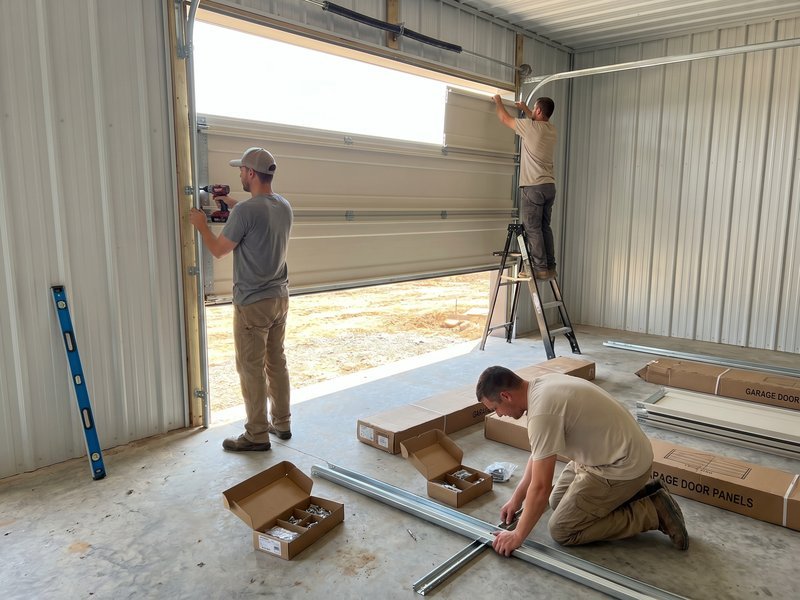 Technician on a ladder fitting a header bracket for a new door
